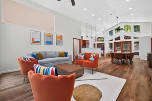Ein modernes Wohnzimmer mit einer Couch, Sesseln, einem Couchtisch und Kunstwerken an der Wand.