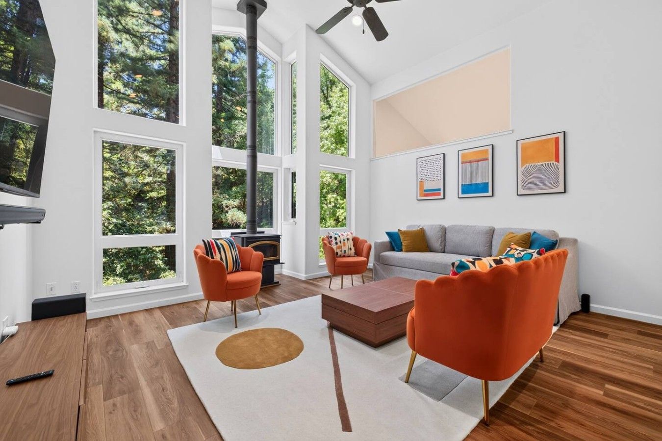 A spacious living room with large windows, a fireplace, and modern furniture.