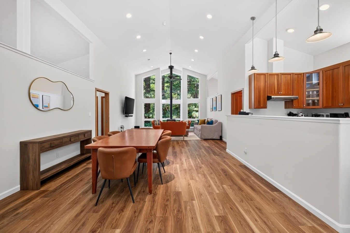 Una cocina amplia con armarios de madera y un comedor con una mesa larga y sillas.