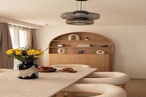 A dining area with a table, chairs, a vase with flowers, a bookshelf, and a pendant light. - Elegant flat - 3BR-8P- Canal Saint-Martin (Paris)