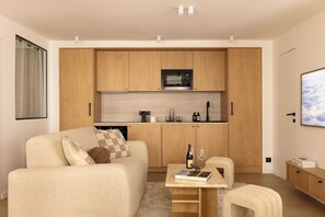Una cocina moderna con armarios de madera, un microondas y un comedor con mesa y sillas.