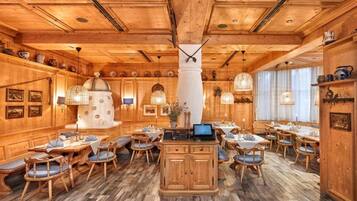 A wooden interior with a central column, dining tables, and chairs.