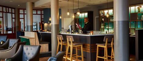 A bar area with stools, a counter, and a bartender.