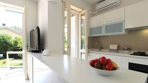Une cuisine moderne dotée d’un grand îlot central, d’un four encastré et d’un panier de fruits.