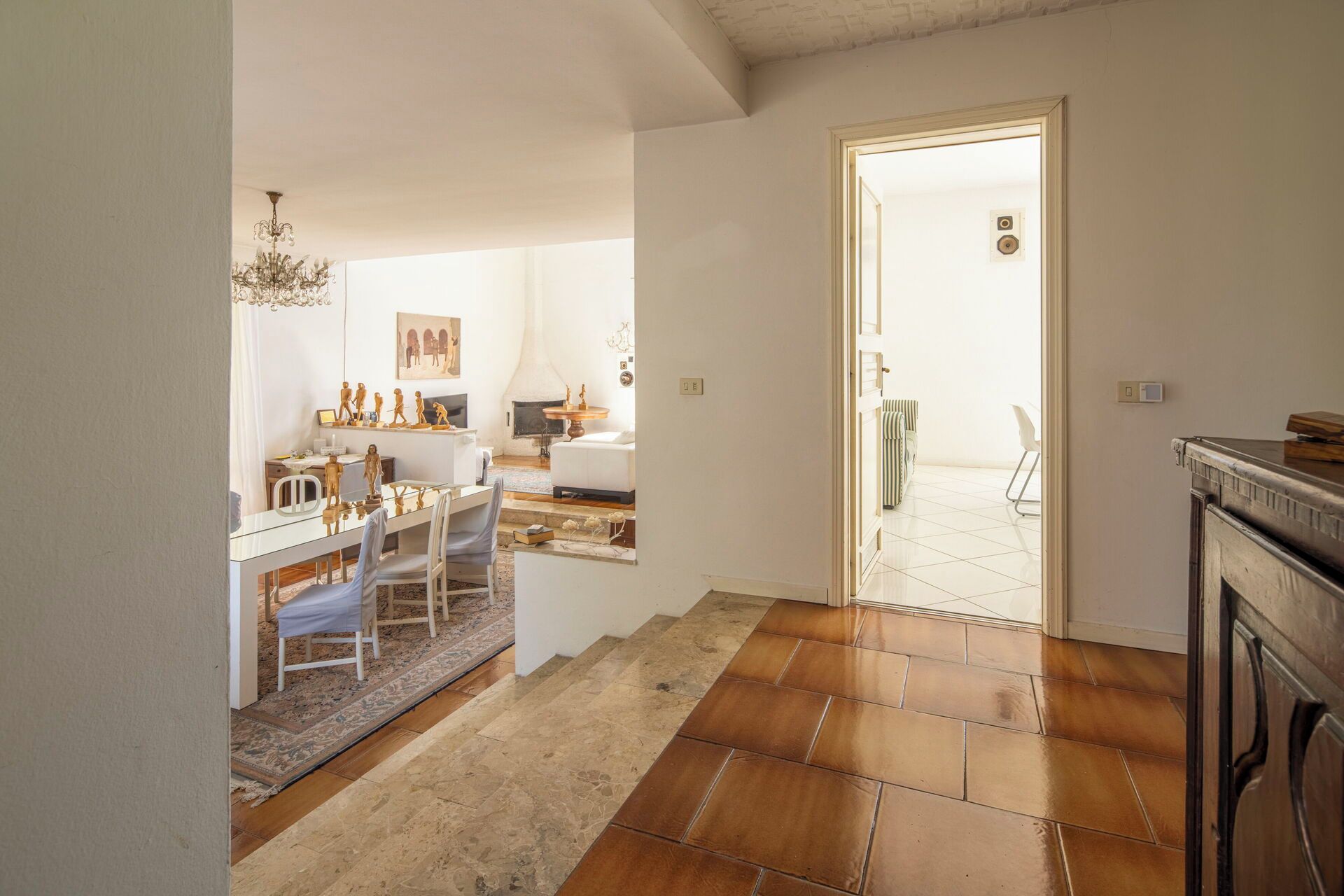A spacious living area with a dining table, chairs, and a fireplace.