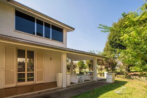 A two-story house with a covered patio area.