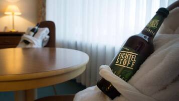 Uma garrafa de cerveja Fichtel Stoff sendo segurada por alguém de roupão.