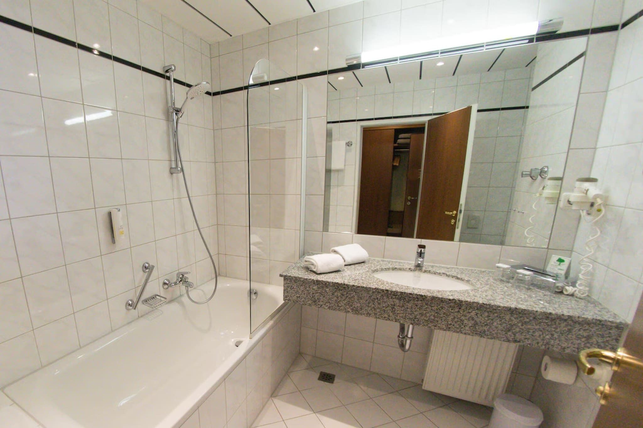 Uma casa de banho moderna com banheira, lavatório e espelho.