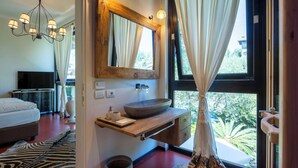 A modern bathroom with a large window, a wooden vanity, a vessel sink, and a zebra-patterned rug. - Villa El Perlè by Geco Vacation Rentals (Padenghe Sul Garda)