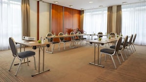 A conference room with a long table, chairs, and a plant.