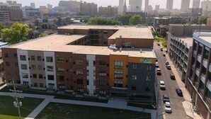 A multi-story building with a flat roof, The Yard logo, and a parking lot with cars.