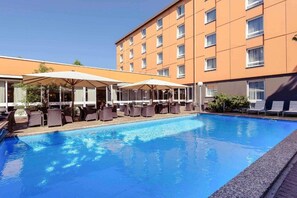 Ein Hotel mit Schwimmbad, Außenbereich und einem mehrstöckigen Gebäude.