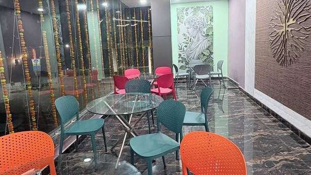 Une salle de conférence dotée de tables en verre, de chaises colorées, d’un mur décoratif et d’un design moderne au niveau du plafond.