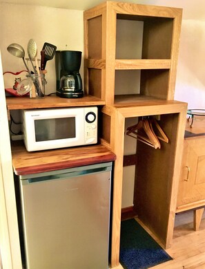 A compact kitchen with a microwave, coffee maker, and wooden shelves. - House with outdoor space and hiking trails, in a peaceful and quiet setting. (Sonnac)