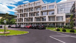 A multi-story hotel with a parking lot and several cars.