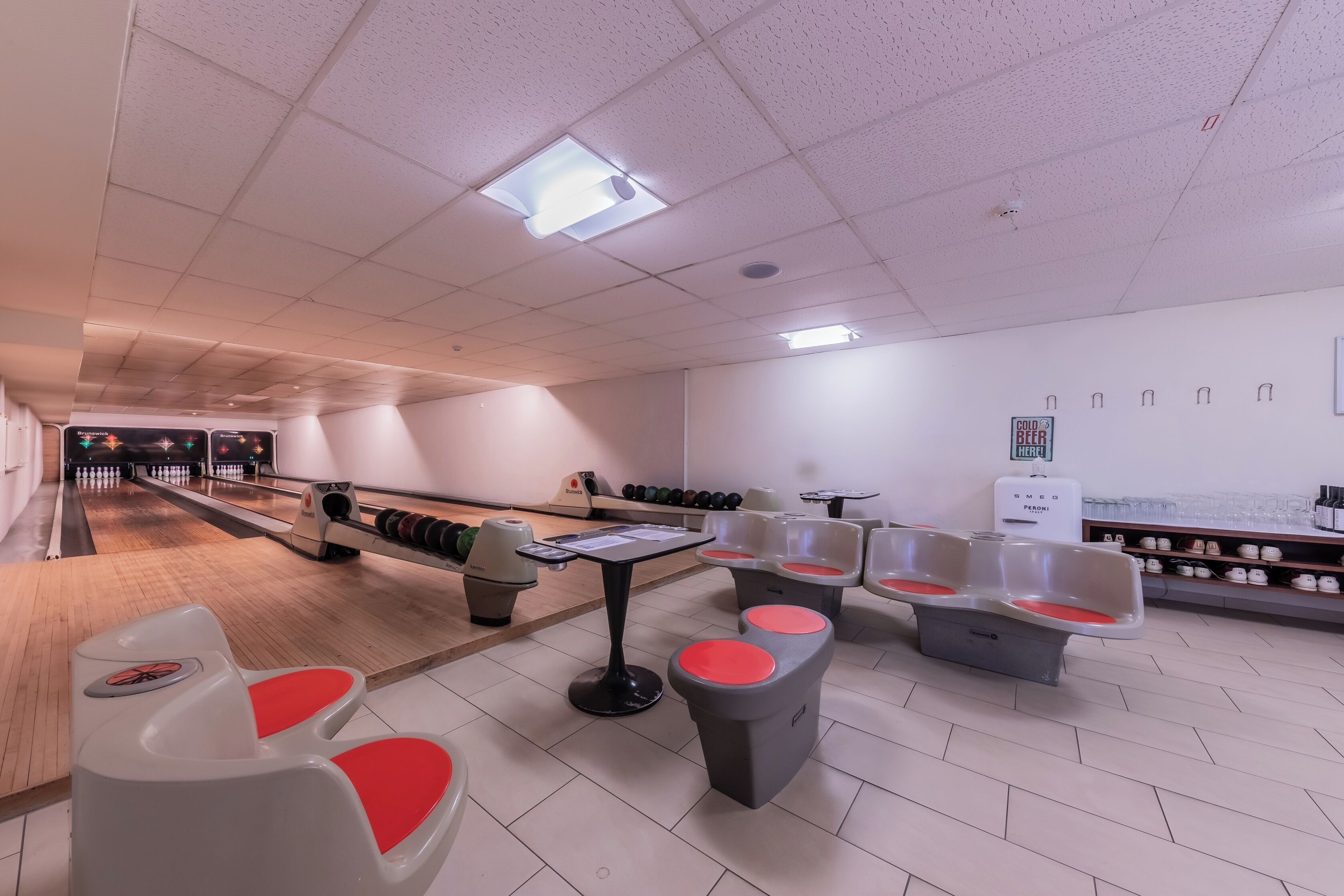 A bowling alley with lanes, seating areas, and a snack bar.