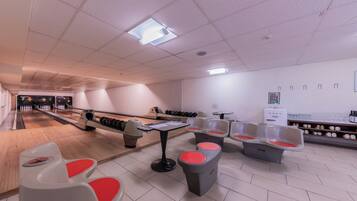 A bowling alley with lanes, seating areas, and a snack bar.
