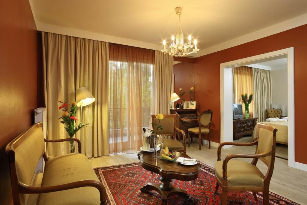 Habitación de hotel con comedor, un espejo grande y una araña.