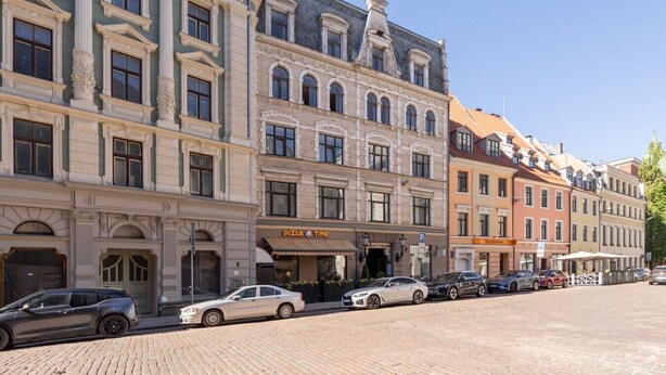Een rij historische gebouwen, op de begane grond een restaurant genaamd 'PIZZA TIME'.