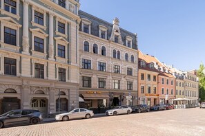 Een rij historische gebouwen, op de begane grond een restaurant genaamd 'PIZZA TIME'.