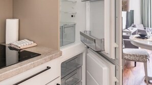 Een moderne keuken met een ingebouwde oven, een magnetron en een koelkast met vriesvak.