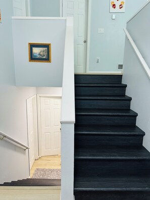 A staircase with dark steps leading to a white door. - Cozy retreat offering comfort and convenience to everything! (Anchorage)