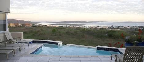 Piscina con vistas al mar y al paisaje distante.