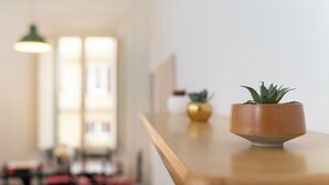 Een houten tafel met een bloempot en een decoratief voorwerp.
