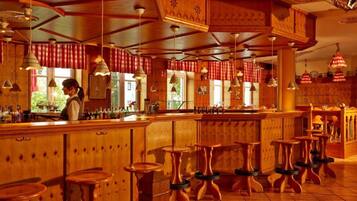 Eine Bar mit Holzeinrichtung und hängenden Pendelleuchten.