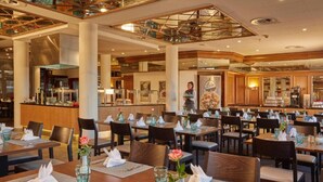 Ein geräumiges Restaurant mit mehreren Tischen, Stühlen und einer Bar.