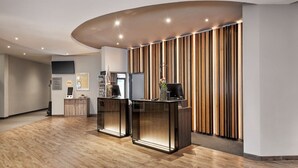A modern reception area with wooden flooring, a curved ceiling, and a vertical wooden panel wall. - Sunday Hotel Köln Hürth Single Room (Hürth)
