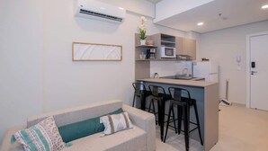 Uma cozinha moderna com uma ilha central, banquetas de bar e micro-ondas embutido.