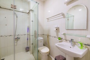 A bathroom with a glass shower enclosure, a toilet, a sink with a mirror above it, and a glass shelf. - Cozy 1-Room KingSizeBed in SGHomestay with AC-1km Bui Vien-City Center HCM (Thành phố Hồ Chí Minh)