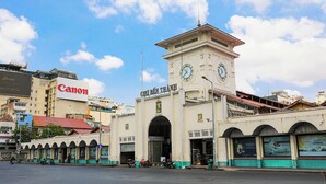 A building with a clock tower, a sign reading 'CHU BENG THANG,' and a Canon sign.