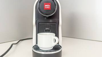 A MIO Coffee espresso machine with a white cup holder and a black base.