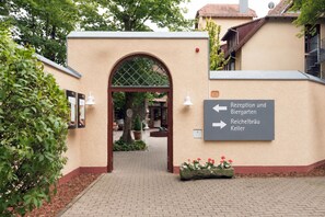 Un área de recepción con un cartel que indica el camino a la recepción, el jardín de cerveza y el Reichelbräu Keller.