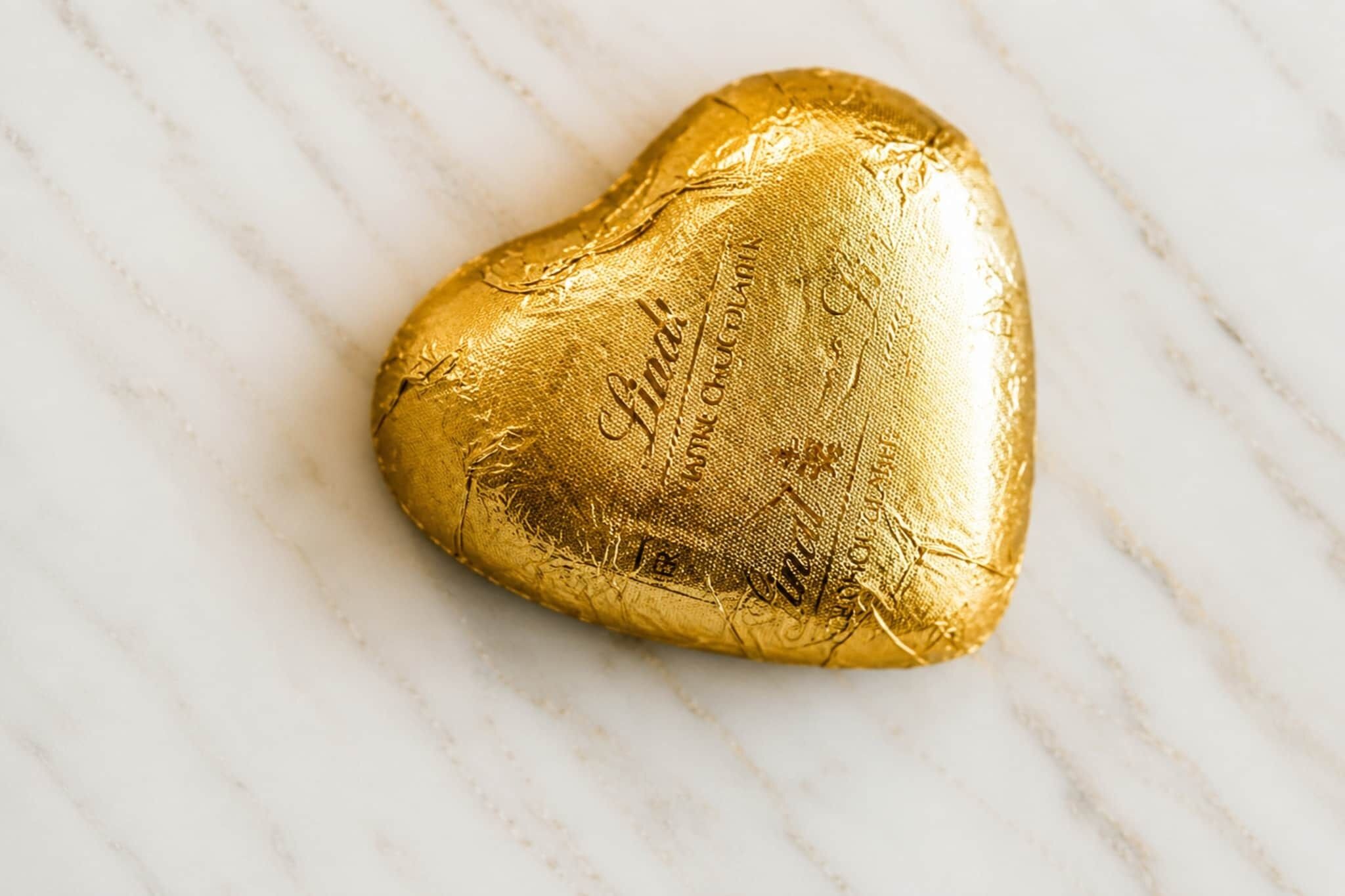 A heart-shaped chocolate bar on a marble surface.