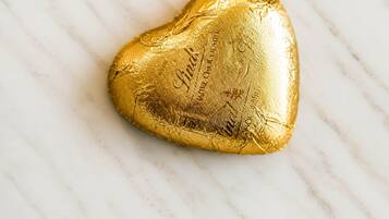 A heart-shaped chocolate bar on a marble surface.