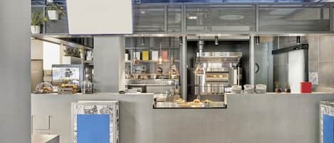 Una cocina moderna con electrodomésticos de acero inoxidable, una isla central y una lámpara colgante.