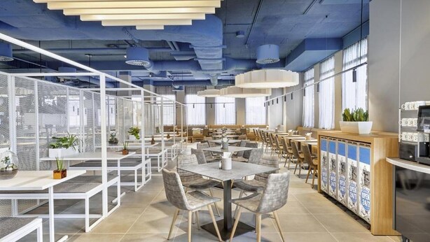 A modern dining area with high tables, chairs, and a bar counter.