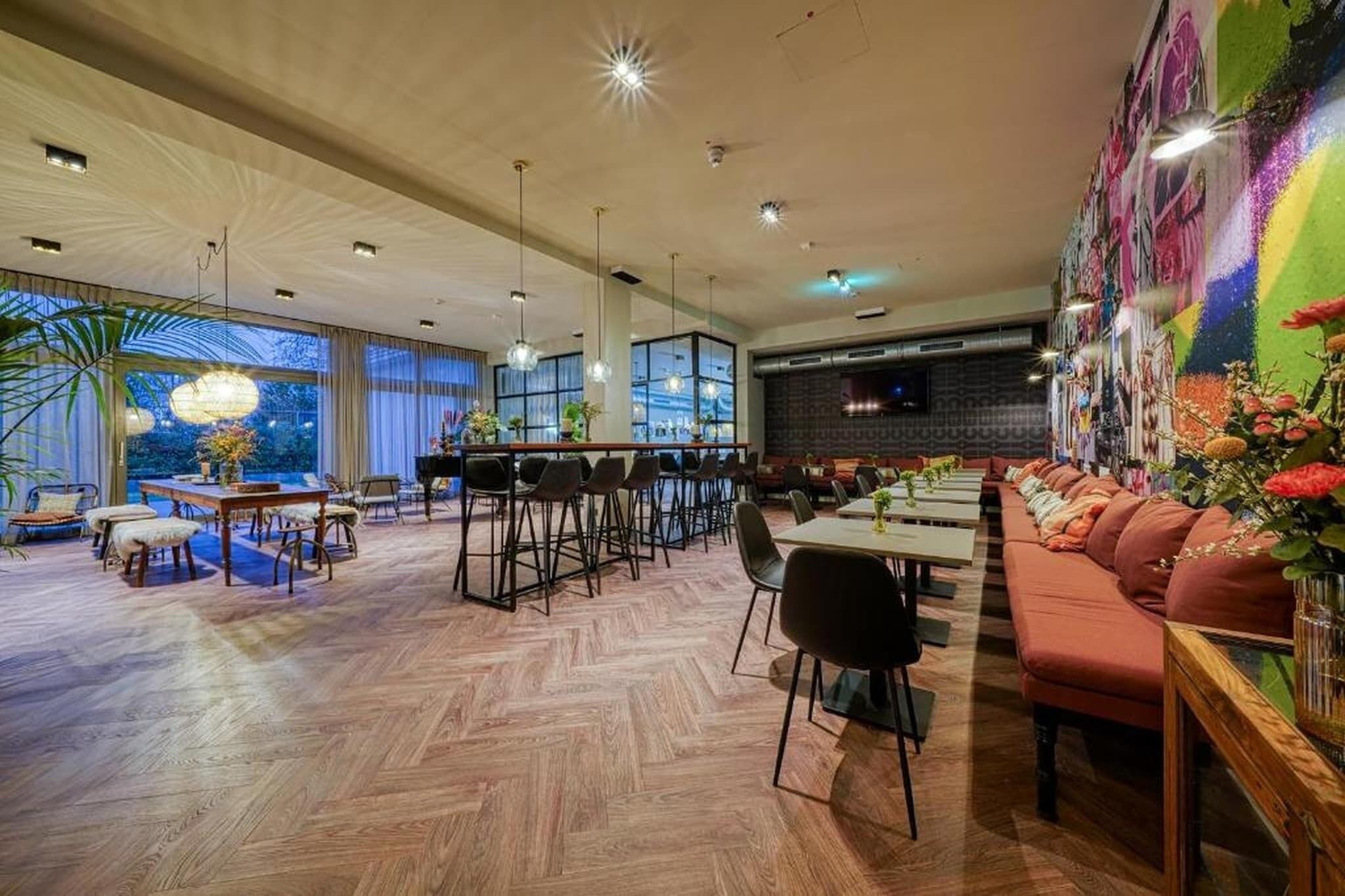 Un vaste espace dédié à la salle à manger, avec de hauts plafonds, un éclairage moderne et une grande fresque murale.