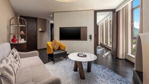 Un salon moderne avec un canapé, une table basse et un téléviseur fixé au mur.