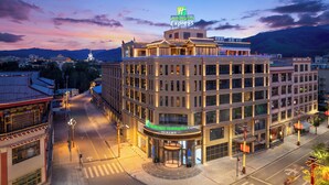 Un hôtel Holiday Inn Express de style architectural traditionnel, situé dans une ville offrant une vue sur les montagnes en arrière-plan.