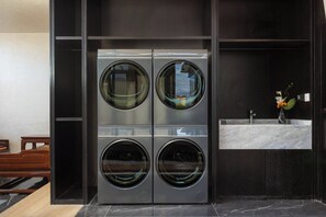A modern bathroom with a built-in washer and dryer unit, a marble sink, and a small wooden bench. - Holiday Inn Express Ganzi by IHG (Garze)