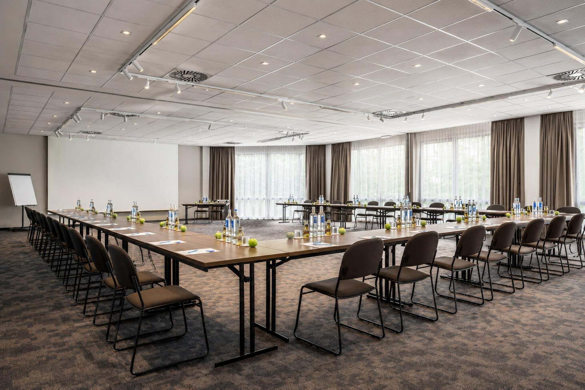 Ein Konferenzraum mit einem langen Tisch, Stühlen und einer Tafel.