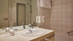 Un bagno con lavandino, specchio, asciugamano e doccia.