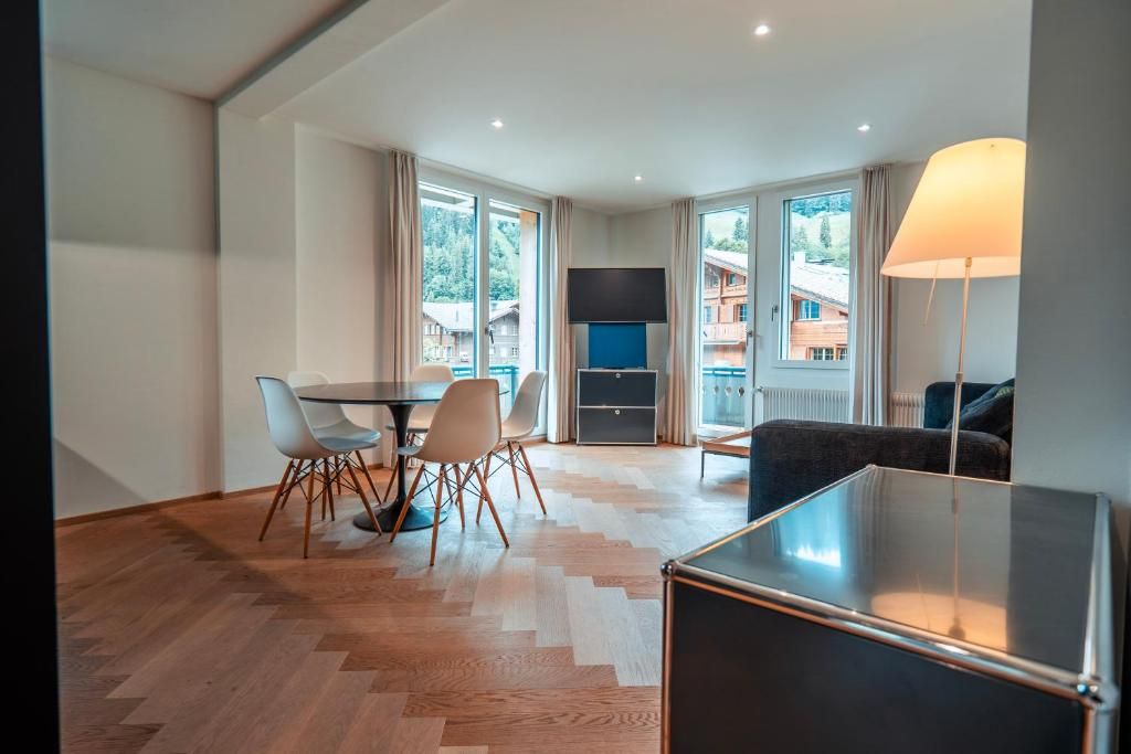 Una sala moderna con comedor, televisor de pantalla plana y sofá.
