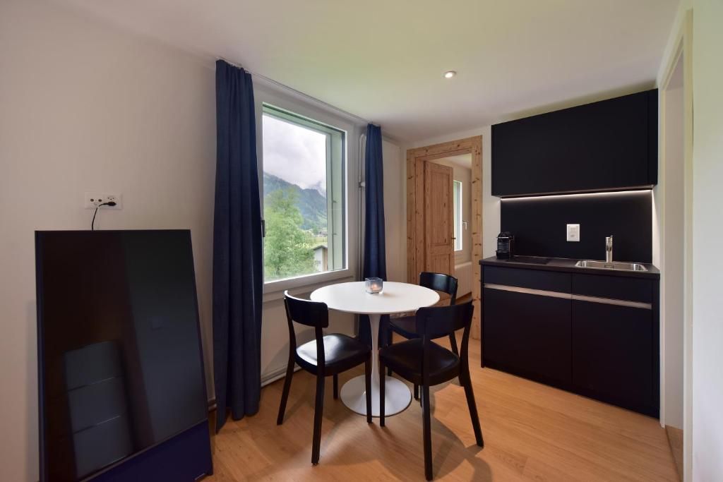 Une cuisine moderne dotée d’une cuisinière intégrée et d’un coin repas avec une table ronde et quatre chaises.