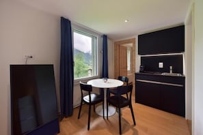 Une cuisine moderne dotée d’une cuisinière intégrée et d’un coin repas avec une table ronde et quatre chaises.