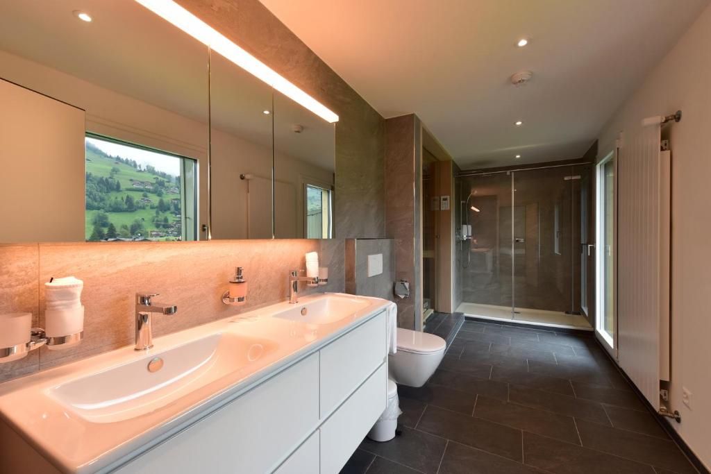 A modern bathroom with a large sink, mirror, and shower.